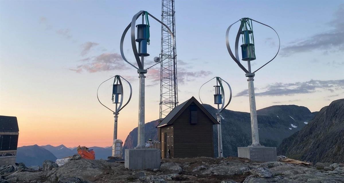Telia sin basestasjon i Trollstigen. I forgrunnen ser ein sjølve basestasjonen med solcellepanel og vindmøller. I bakgrunnen er det fjellandskap.