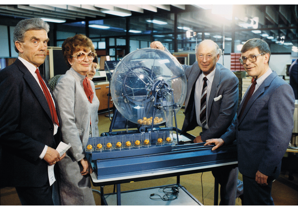 Figur 5.1 Fra den aller første Lotto-trekninga hos Norsk Tipping på Hamar i 1986. F.v: Roald Dalen og Ruth Skaare Botner frå Statskontrollen, adm. dir. Tore Sanderud og informasjonssjef Odd Kjell Skjeggestad