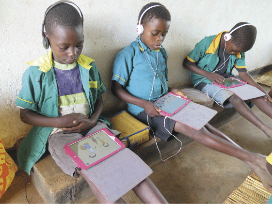 Figure 5.1 Pupils in a school in Njewa just outside Lilongwe, Malawi, concentrating on drawings and numbers on tablets.