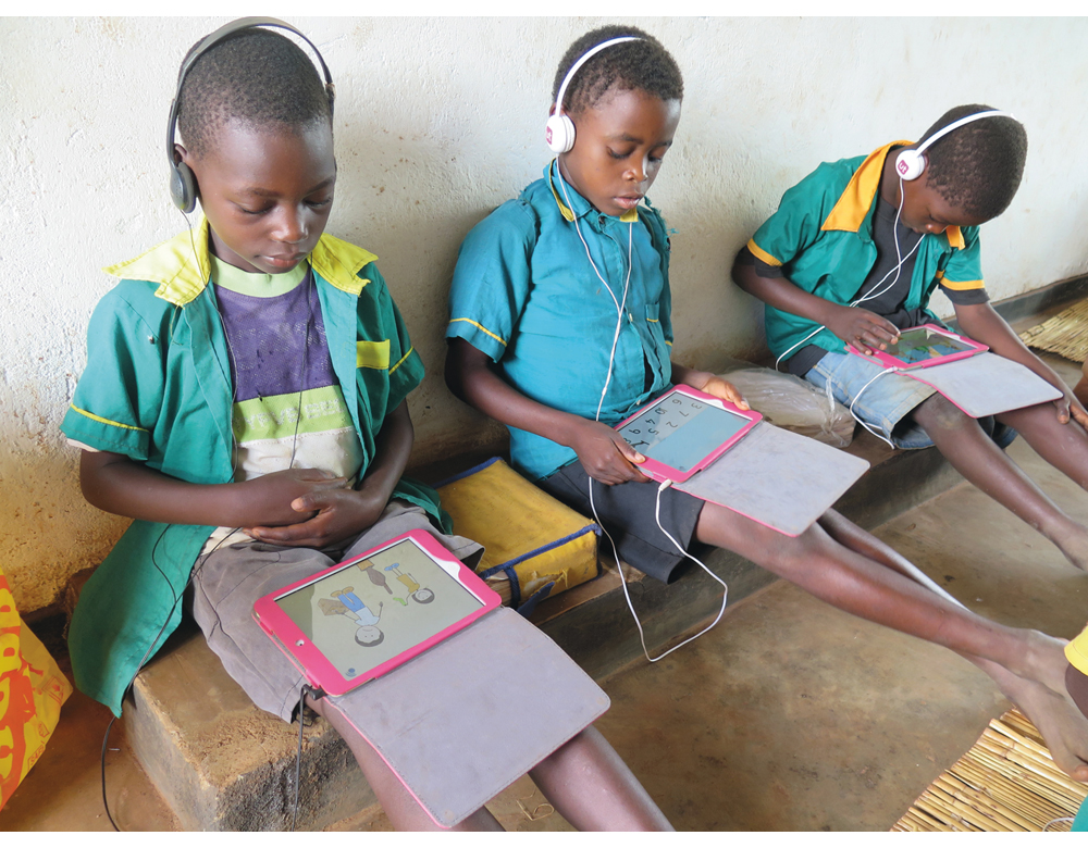 Figur 2.4 De er intenst opptatt med figurer og tall på lesebrettet, elevene på skolen i Njewa utenfor Lilongwe i Malawi.