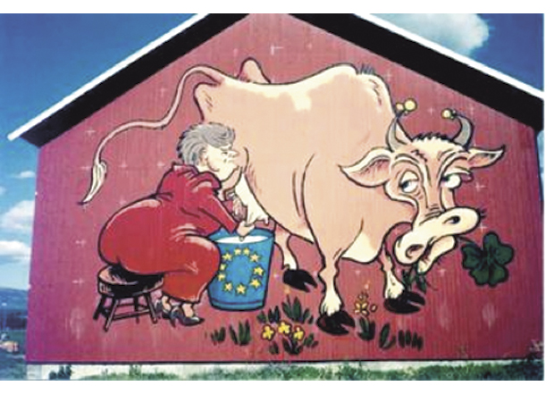 Figur 18.1 I 1994 malte en bonde på Vang i Valdres et bilde på låveveggen sin av Gro Harlem Brundtland som melket norsk landbruk for å fylle EU-bøtta. Bildet ble et kjent symbol, og solgte over 24000 t-skjorter, 2400 caps, 5000 pins, 15000 postkort og 3000 klistremerker.