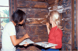 Figur 4.9 Konservering av museumsgjenstander og interiører krever nøyaktighet og tålmodighet. Her utbedres skader i Olav Hanssons dekorasjoner i Cappelen-stugu fra Telemark på Norsk Folkemuseum.