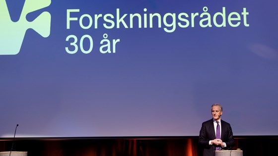 Statsminister Jonas Gahr Støre står på scenen på Vippa, med stor Forskningsrådet-logo som bakgrunn.
