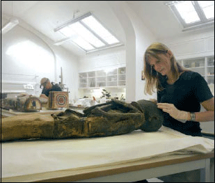 Figur 6.1 Universitetsmuseenes kunnskapsproduksjon er materielt basert.
Her arbeider konservatorer ved Kulturhistorisk museum med en egyptisk
mumie.