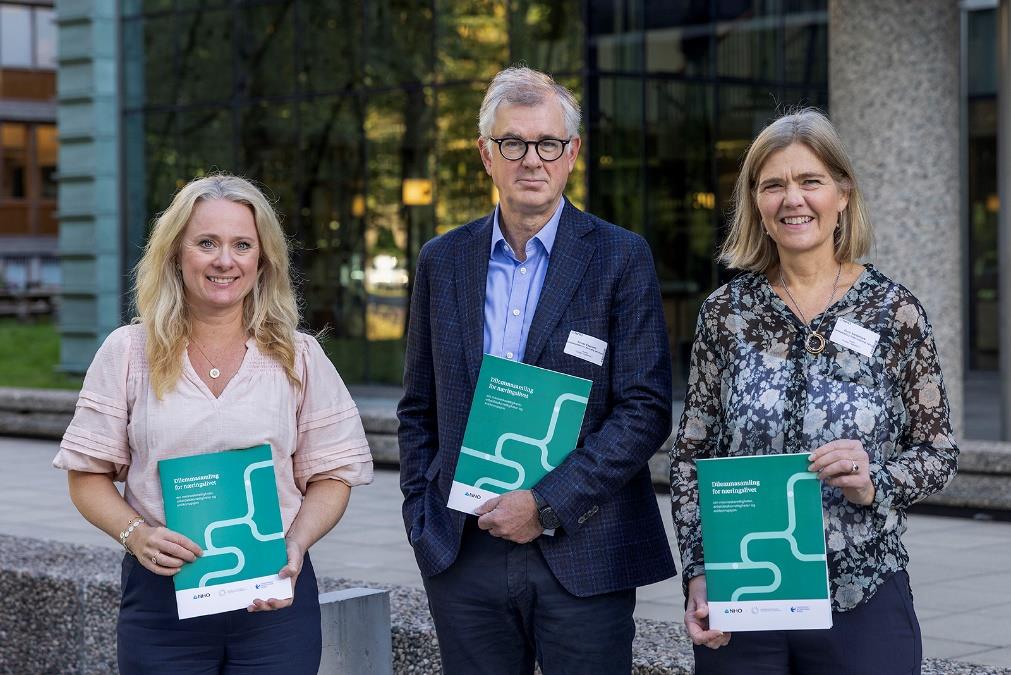 Anniken Haugli, Frode Elgesem og Guro Slettemark står side om side utendørs, med hver sin trykksak i hendene. De grønne forsidene på dilemmasamlingen er godt synlige. Foto: Thomas Kleiven