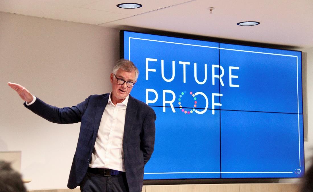 Frode Elgesem gestikulerer mens han holder innlegg. Han står foran en skjerm der det står Future Proof. Foto: Future-Proof