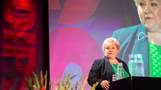 Statsminister Erna Solberg står ved talerstolen på DIPS-forum.