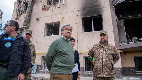 Flere personer foran et utbombet hus