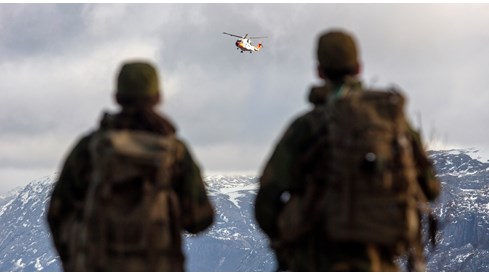 To soldater ser opp på et Sar Queen-helikopter i luften. Foto: Christian Nørstebø / Forsvaret To soldater ser opp på et Sar Queen-helikopter i luften.
