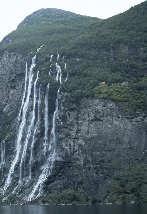 Figur 8.4 «… der som ingen skulle tru at nokon kunne
bu» heter det i visen om Anne Knutsdotter. Hyllegården
Knivsflå ved siden av fossene De sju søstre i
Geirangerfjorden. Kombinasjonen av den storslåtte naturen
og kulturelementene i de norske fjordene...