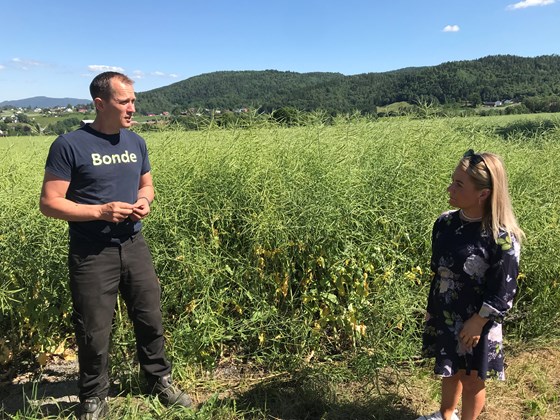 Henrik Kjeldsen på Holla gård i Ulefoss viser landbruks- og matminister Sandra Borch en åker med høstraps