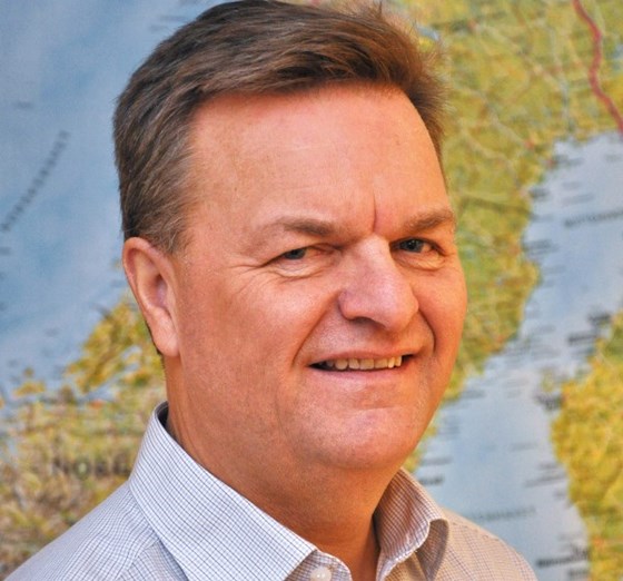 Portrettbilde av Hallgeir Aalbu foran et kart.
