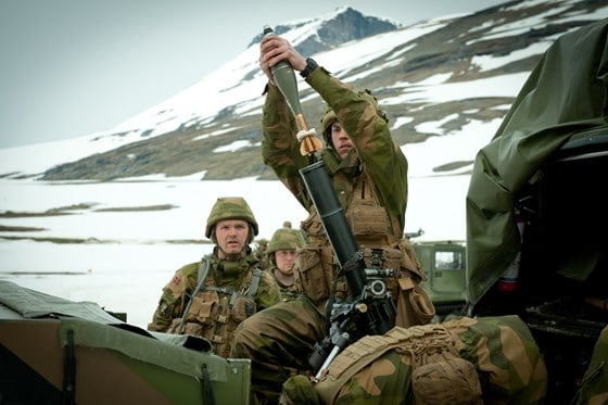 Bildet viser soldater som håndterer en bombekastergranat.