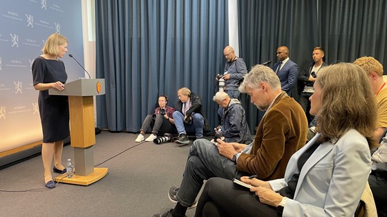 Bilde av utenriksminister Anniken Huitfeldt som holder pressekonferanse fra talerstol med publikum