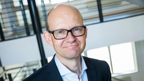 Portrettbilde av Geir Axelsen, innendørs i kontorbygg.