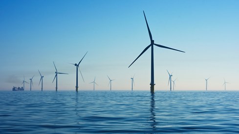 Noreg har ein ambisjon om at det innan 2040 skal tildelast område for 30 000 MW havvindproduksjon. Foto: Unsplash Illustrasjonsbilde av havvind-turbiner