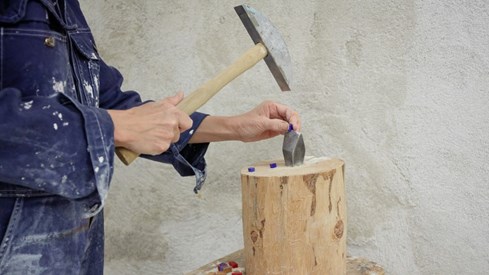 Muralverksted på Lilleborg. Foto: Marta Anna Løvberg / Kulturrådet Ser hendene til kunstner som deler en liten blå glasstein med hammer.