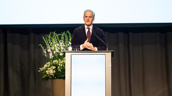 Jonas Gahr Støre står bak en talerstol.