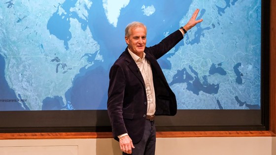 Prime Minister Støre points at Scandinavia on a map.