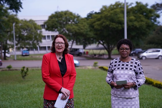 Bilde av Statssekretær Bjørg Sandkjær i rød jakke møtte Malawis utenriksminister Nancy Gladys Tembo utenførs i Lilongwe