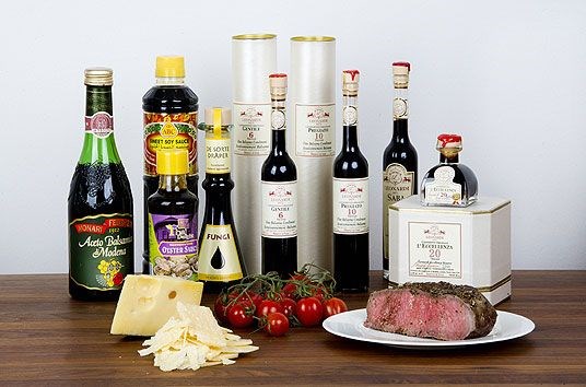 Bildet viser typiske kilder for smaken umami; vellagret balsamico eddik finnet på opptil 30 år finnes i velutstyrte kolonialbutikker, soyasaus, vellagrede oster som Jarlsberg og Parmesan. Andre kilder er stekt oksekjøtt og tomater.